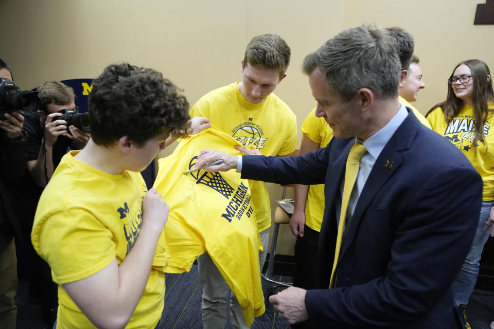 University of Michigan basketball coach Dusty May autographs a T-Shirt for the Maize Rage student group after being introduced as the new NCAA college basketball head coach Tuesday, March 26, 2024, in Ann Arbor, Mich. (AP Photo/Carlos Osorio)