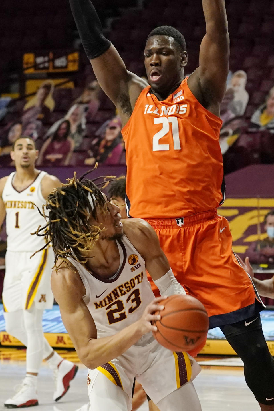 Minnesota's Brandon Johnson (23) eyes the basket as Illinois' Kofi Cockburn (21) hovers over him in the first half of an NCAA college basketball game, Saturday, Feb. 20, 2021, in Minneapolis. (AP Photo/Jim Mone)