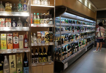 A man looks at Sake imported from Japan at a supermarket in Singapore October 6, 2016. REUTERS/Edgar Su