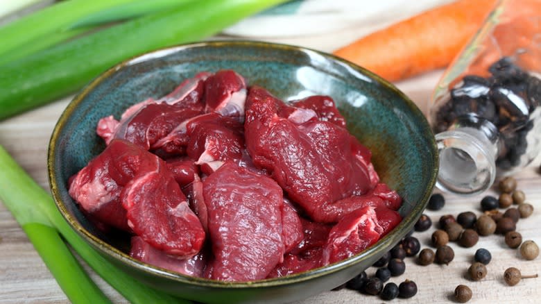 Venison in bowl and juniper berries