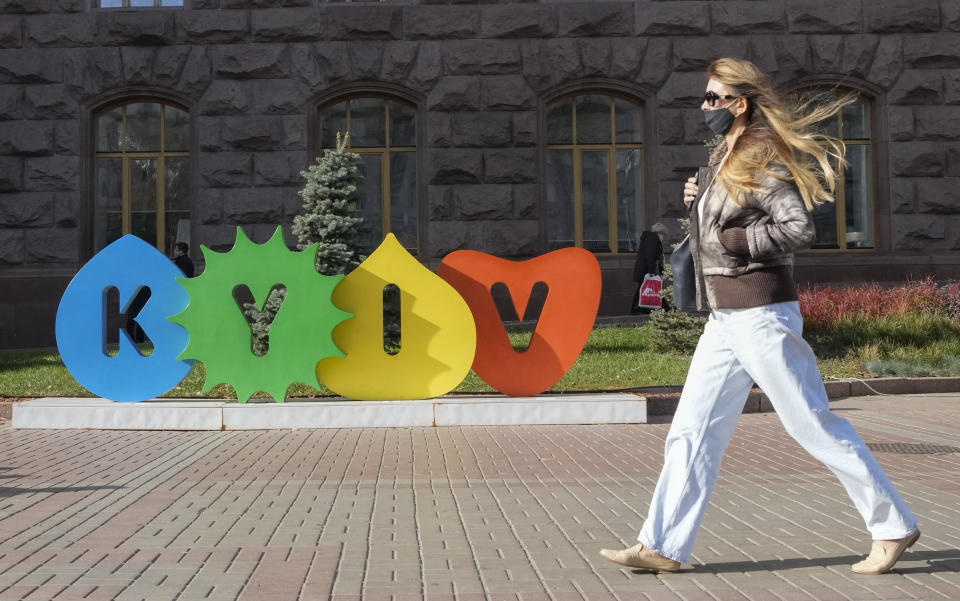 A woman wearing a face mask to protect against COVID-19 walks along Kyiv's main Khreshchatyk Street, Ukraine, Thursday, Oct. 21, 2021. Coronavirus infections and deaths in Ukraine have surged to all-time highs amid a laggard pace of vaccination, which is one of the lowest in Europe. (AP Photo/Efrem Lukatsky)