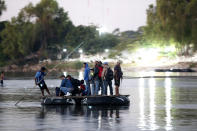 Migrantes hondureños cruzan el río Suchiate a bordo de una balsa hecha con tubos interiores de tractores y tablones de madera en la frontera entre Guatemala y México en Tecún Umán, Guatemala, el viernes 18 de enero de 2019. (AP Foto / Moisés Castillo)