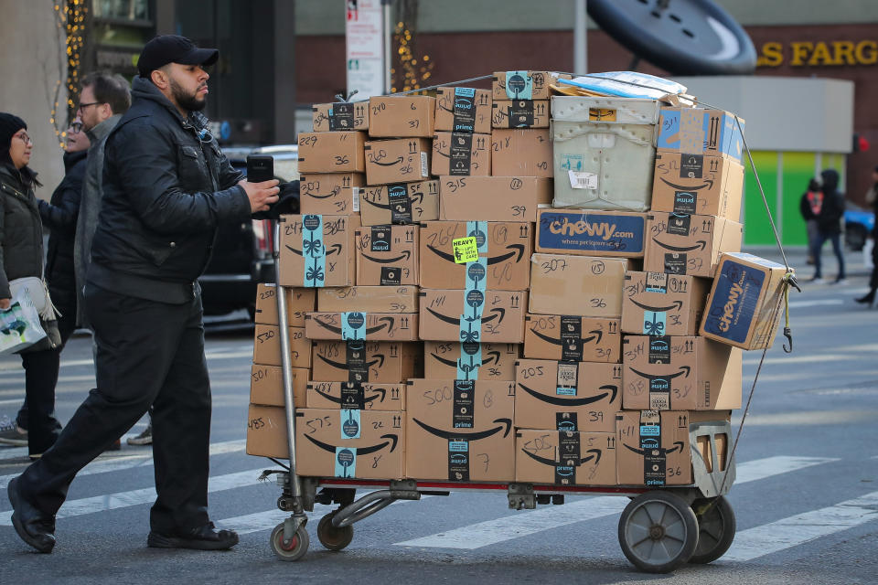 A delivery person pushes a cart full of Amazon boxes in New York City, U.S., February 14, 2019. REUTERS/Brendan McDermid