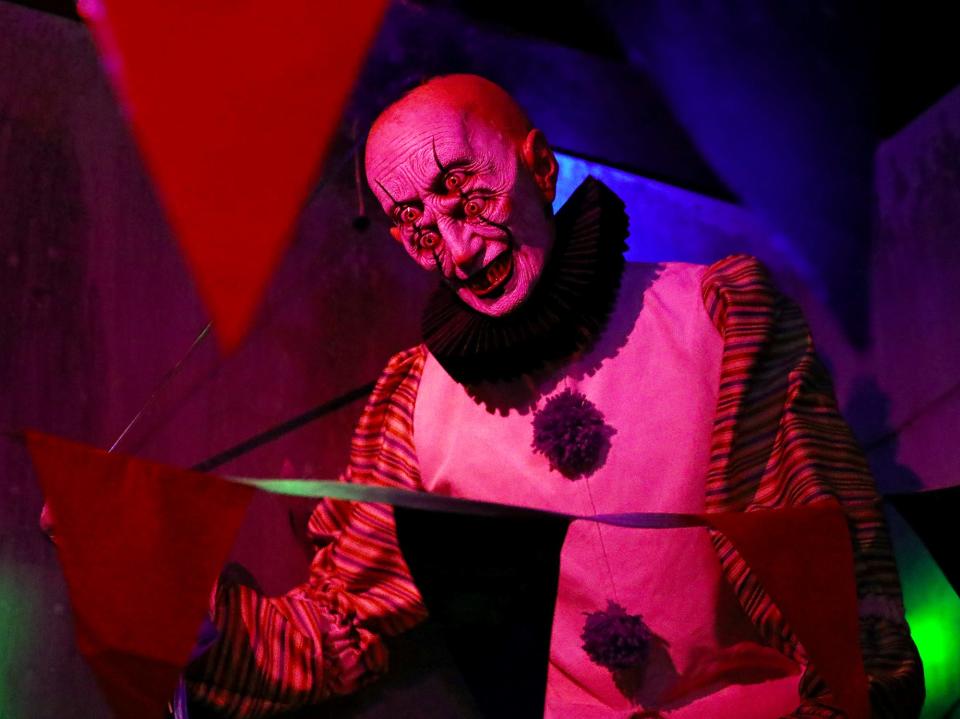 A clown has an extra pair of eyes out for the next guest at the Akron Haunted Schoolhouse.