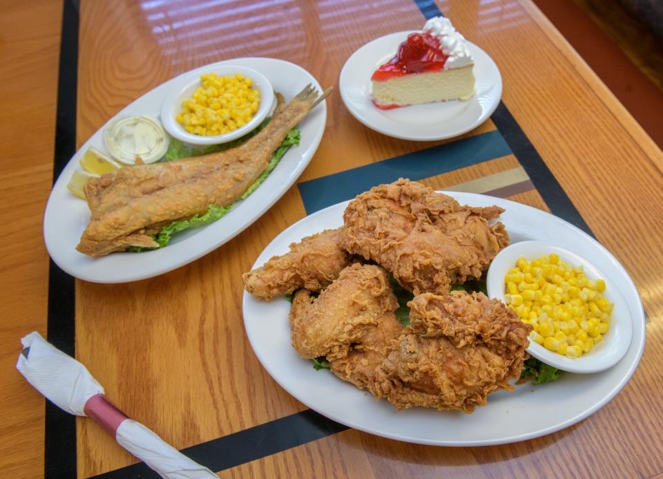 A pair of signature dishes at The 520 Cafe are the fried chicken and fried catfish, along with a large slice of strawberry cheesecake.