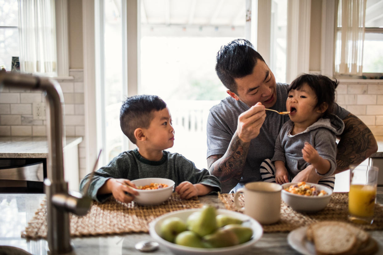 Father and children having breakfast in kitchen