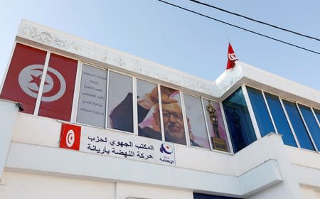 A picture of Rached Ghannouchi, leader of the moderate Islamist party Ennahda is seen on the windows of the party headquarters in Ariana