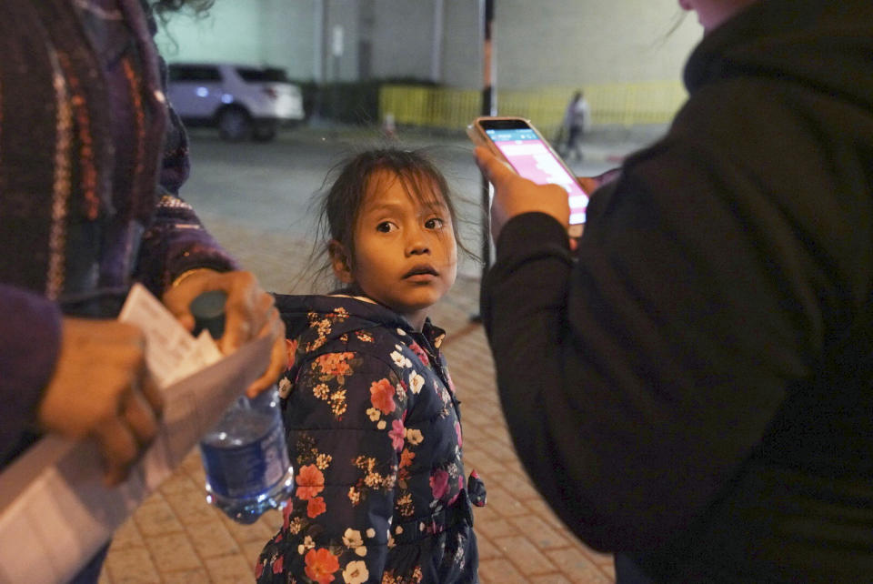 A 7-year-old asylum-seeker waits as her mother Isabel, right, and immigration lawyer Charlene D'Cruz, left, as they figure out where they will be spending the night after being processed at the Port of Entry in Brownsville, Texas, Tuesday, Dec. 17, 2019. The girl who is unable to contain her own waste due to a congenital illness and who had been refused entry to the United States three times has finally been allowed into the country. (AP Photo/Veronica G. Cardenas)