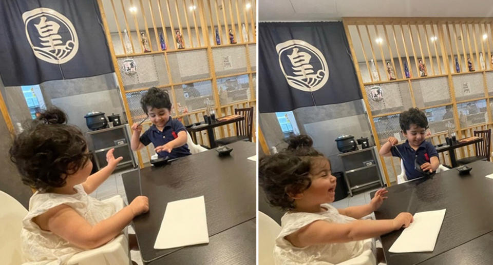 Two young children sit at a table in high chairs.