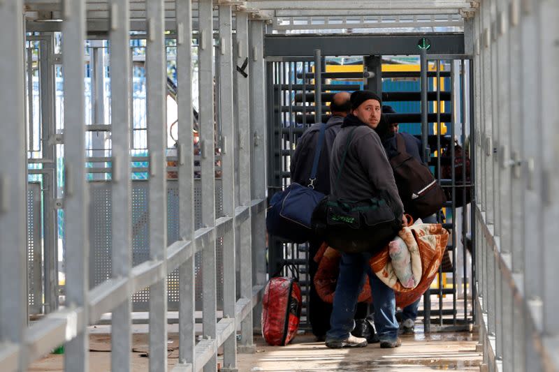 Palestinians working in Israel head to work through an Israeli checkpoint, near Hebron in the Israeli-occupied West Bank