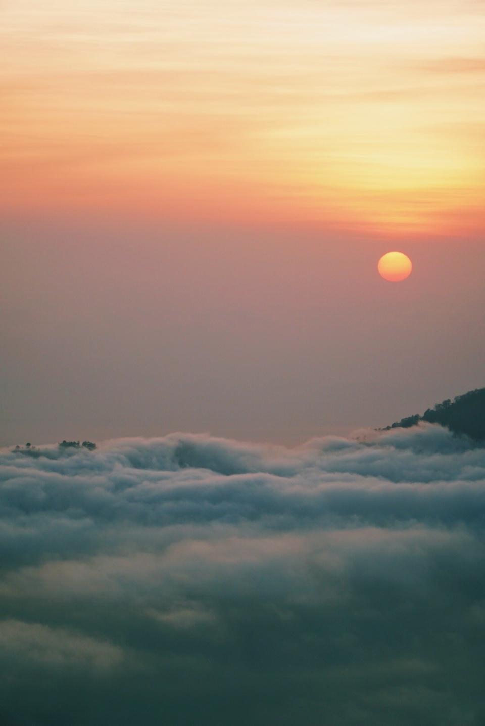 The sun rising over Mount Batur and the clouds.