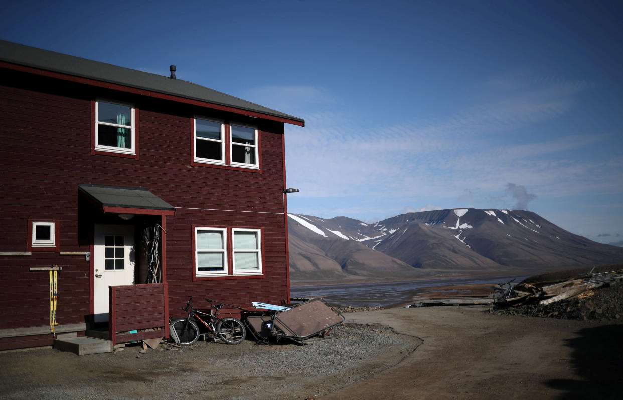 A residential house is seen in front of snow capped mountains in the town of Longyearbyen in Svalbard, Norway, August 4, 2019. REUTERS/Hannah McKay      SEARCH "SVALBARD CLIMATE" FOR THIS STORY. SEARCH "WIDER IMAGE" FOR ALL STORIES.