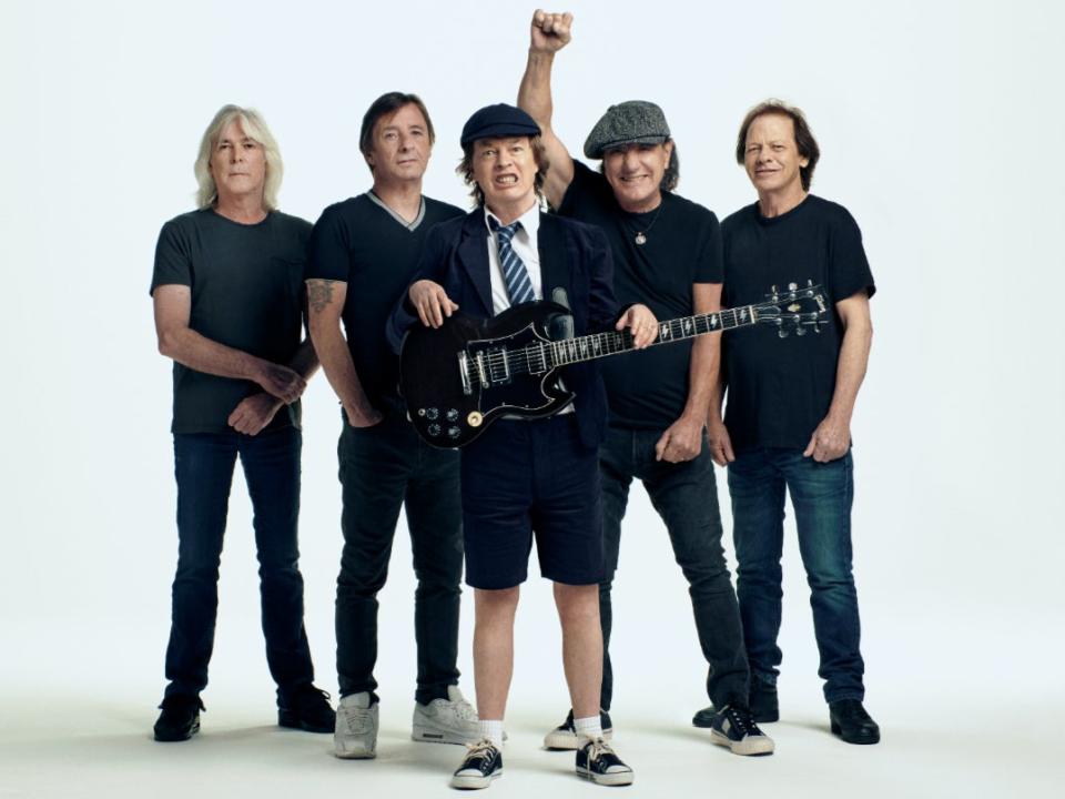 <p>AC/DC pose, with frontman Angus Young dressed in his familiar schoolyard attire</p>Josh Cheuse