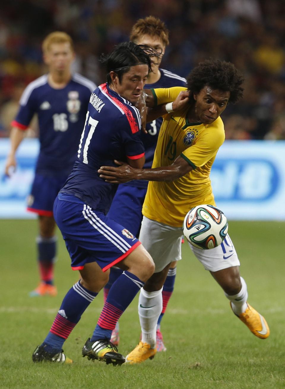 Japan&#39;s Ryota Morioka (L) fights for the ball against Brazil&#39;s Willian Borges da Silva during their friendly soccer match at the national stadium in Singapore October 14, 2014. REUTERS/Edgar Su (SINGAPORE - Tags: SPORT SOCCER)