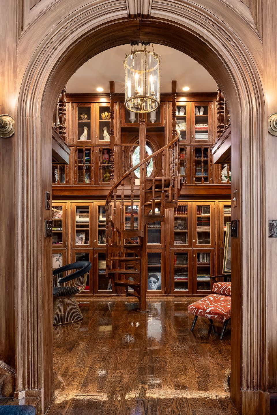 custom bookcases spanning two whole floors and connected by a spiral ladder