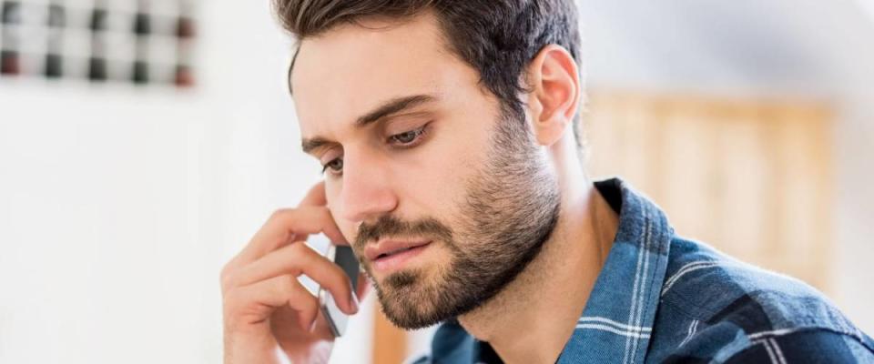 Man talking on mobile phone at home