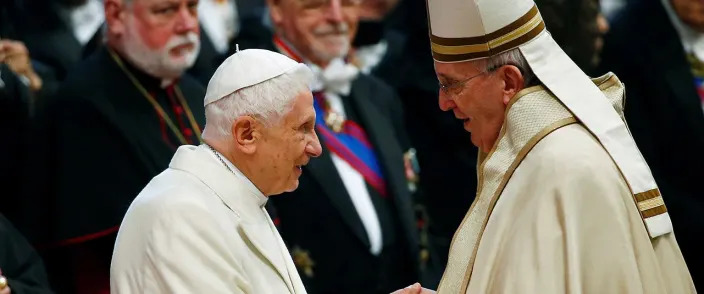 Pope Francis shakes hands with Pope Emeritus Benedict XVI in 2015