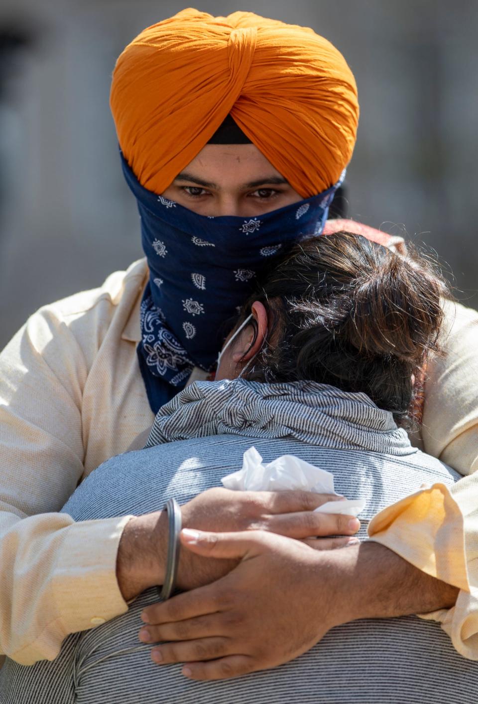 Darshdeep Singh gets a hug on Sunday, April 18, on Monument Circle during a vigil for the eight people who were recently killed in an overnight shooting at a Fed Ex Ground Plainfield Operations Center on Indianapolis' southwest side. 