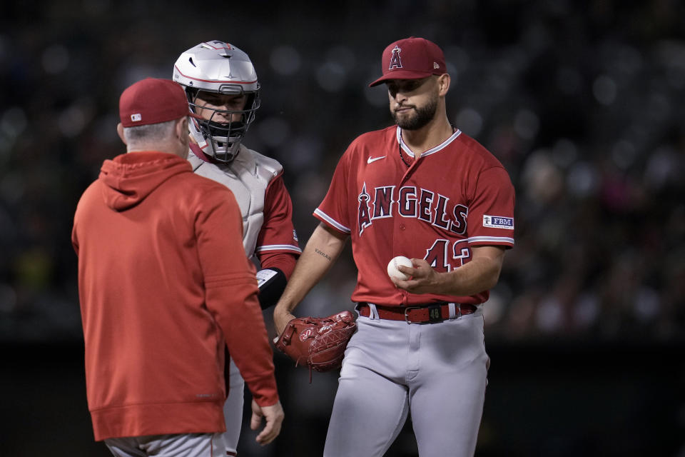 Los Angeles Angels pitcher Patrick Sandoval, right, hands the ball over to manager Phil Nevin as he is pulled during the fourth inning of the team's baseball game against the Oakland Athletics on Friday, Sept. 1, 2023, in Oakland, Calif. (AP Photo/Godofredo A. Vásquez)