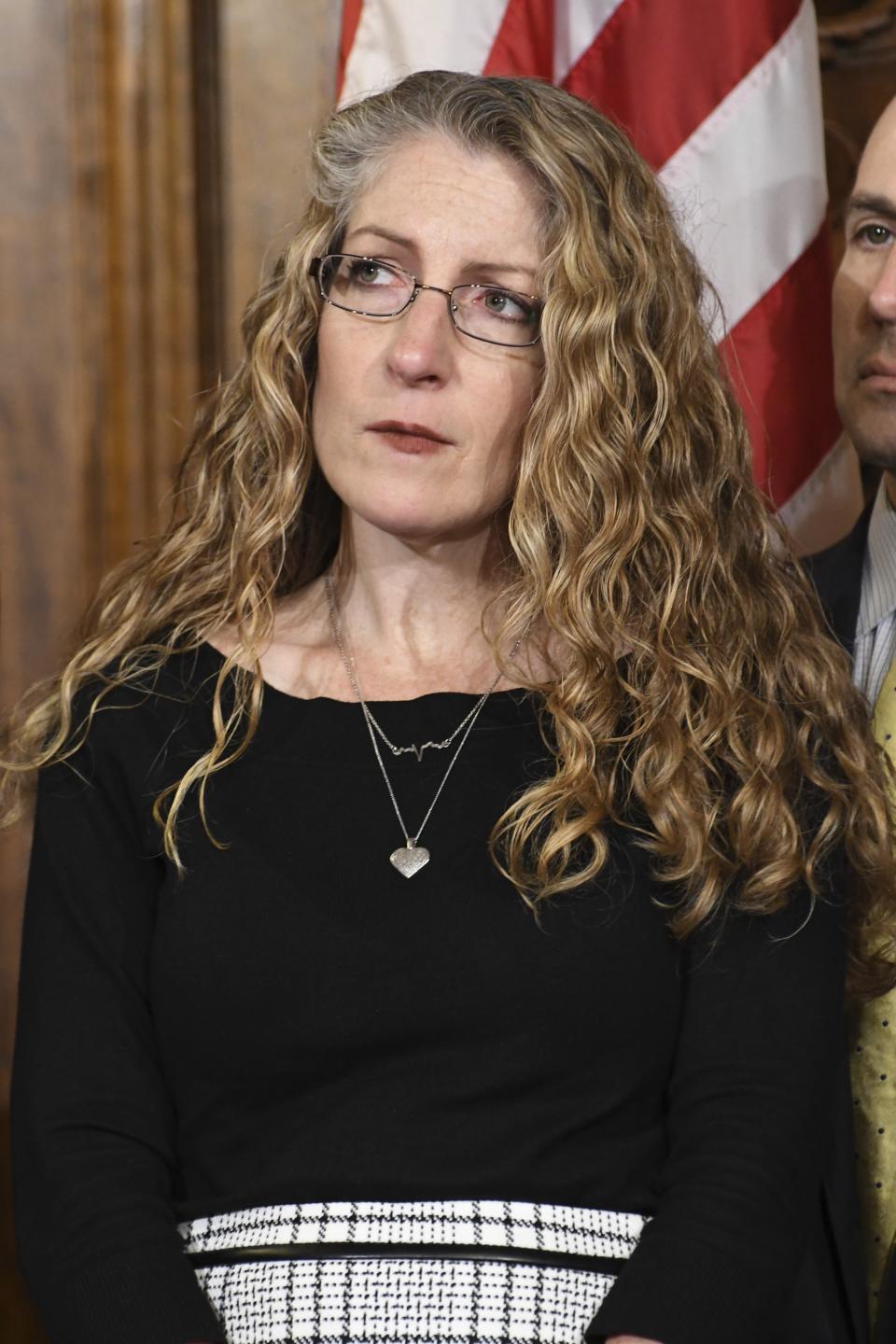 Evelyn Piazza listens to Gov. Tom Wolf of Pennsylvania speaking at a news conference in his Capitol reception room Friday, Oct. 19, 2018 in Harrisburg, Pa., before he signs anti-hazing legislation inspired by her son, Penn State student Tim Piazza, who died after a night of drinking in a fraternity house. (AP Photo/Marc Levy)