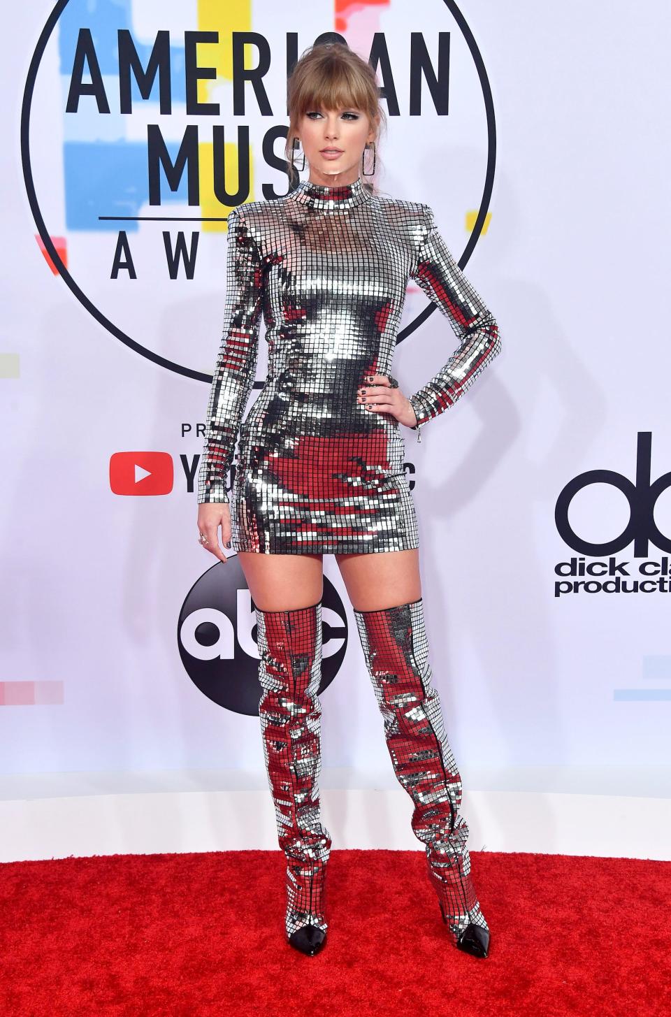 Taylor Swift wears a silver dress and boots at the 2018 American Music Awards.
