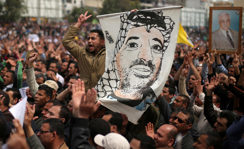 Palestinian Authority employee holds a poster of late Palestinian leader Yasser Arafat in Gaza City