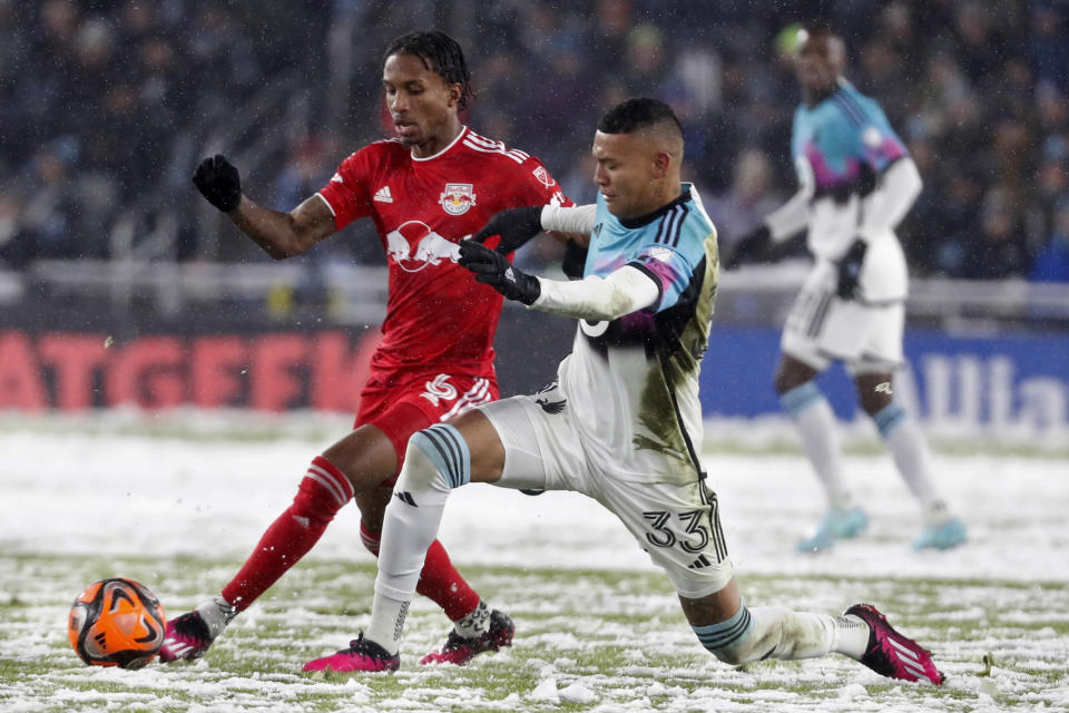 CORRECTS TO ST. PAUL, MINN., NOT MINNEAPOLIS - New York Red Bulls defender Kyle Duncan, left, competes for the ball with Minnesota United midfielder Kervin Arriaga (33) in the first half of an MLS soccer game Saturday, March 11, 2023, in St. Paul, Minn. (AP Photo/Bruce Kluckhohn)