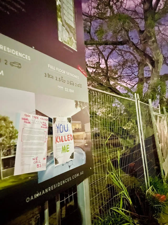 Housing development promotional board with protest signs attached