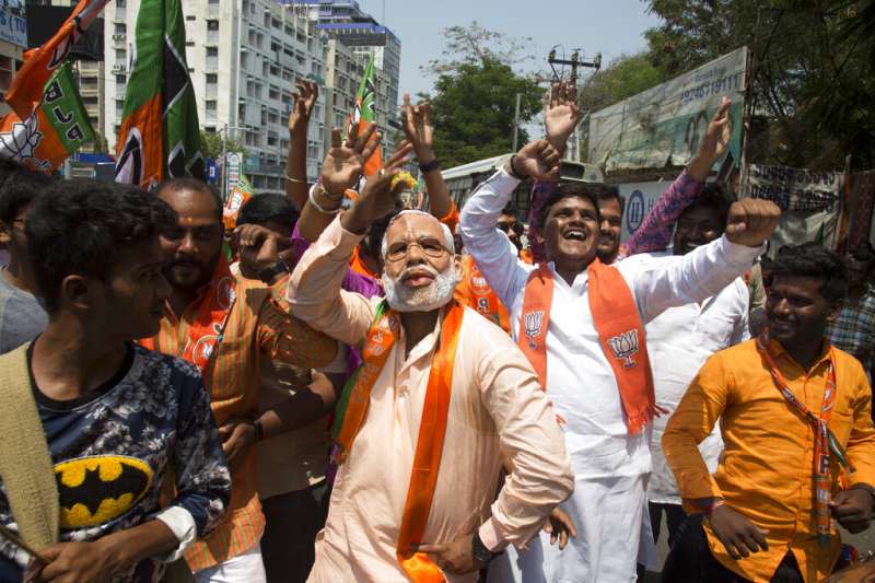 印度總理莫迪的支持者戴其面具跳舞。（AP）