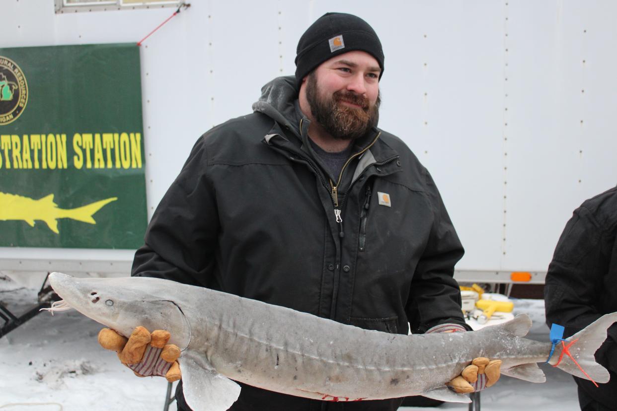 Angler Charles Jett shows off the sturgeon he caught on Saturday, Feb. 4, 2023. Jett was the first angler to catch a fish during the early morning start of lake sturgeon season. The length of the male fish was 49 inches and it weighed 30 pounds.