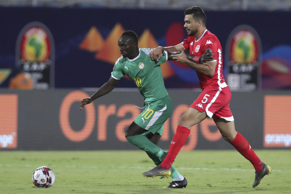 Senegal's Sadio Mane, left, goes for the ball pasty Tunisia's Oussama Hadadi during the African Cup of Nations semifinal soccer match between Senegal and Tunisia in 30 June stadium in Cairo, Egypt, Sunday, July 14, 2019. (AP Photo/Hassan Ammar)