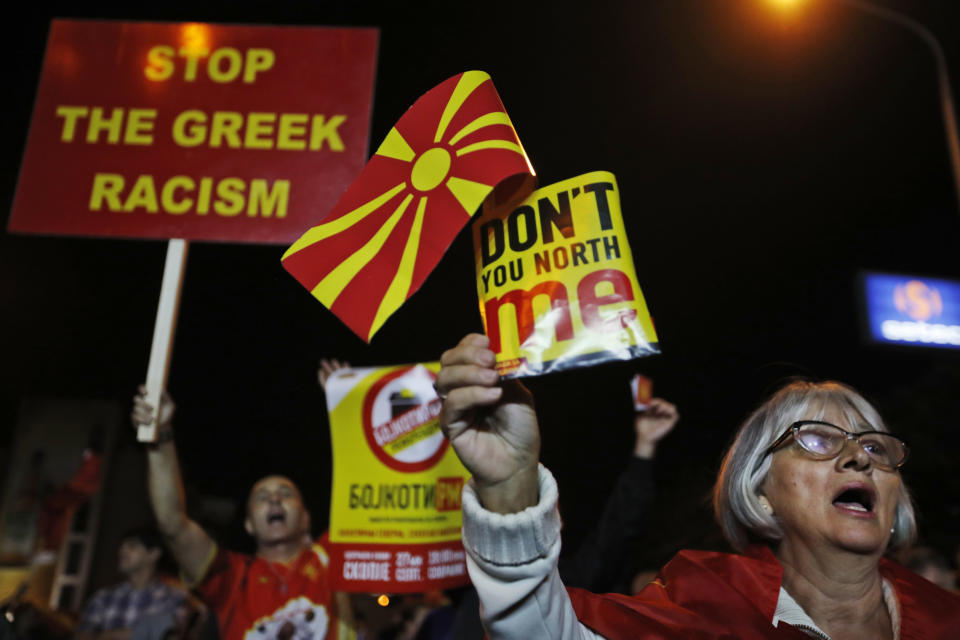 Supporters of a movement for voters to boycott the referendum, holding placards and national flags chant slogans as they celebrate in central Skopje, Macedonia, after election officials gave low turnout figures, Sunday, Sept. 30, 2018. The crucial referendum on accepting a deal with Greece to change the country's name to North Macedonia to pave the way for NATO membership attracted tepid voter participation Sunday, a blow to Prime Minister Zoran Zaev's hopes for a strong message of support. (AP Photo/Thanassis Stavrakis)