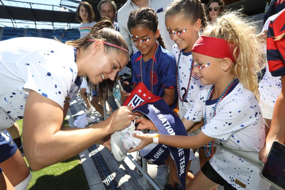 Alex Morgan signs autographs for fans before an international friendly against Wales.