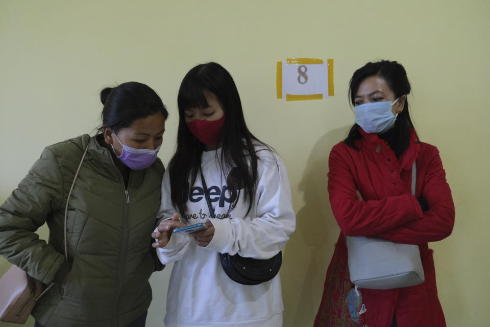 Nurses look at instructions regarding vaccine protocol on a mobile phone after being administered the COVID-19 vaccine at the District Hospital in Ukhrul, in the northeastern Indian state of Manipur, Saturday, Jan. 16, 2021. India started inoculating health workers Saturday in what is likely the world's largest COVID-19 vaccination campaign, joining the ranks of wealthier nations where the effort is already well underway. (AP Photo/Yirmiyan Arthur)