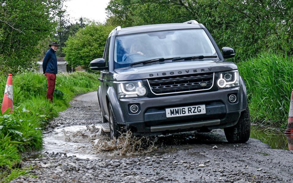 Motor vehicles struggle to pass the pothole on Warrens Lane in Wiltshire