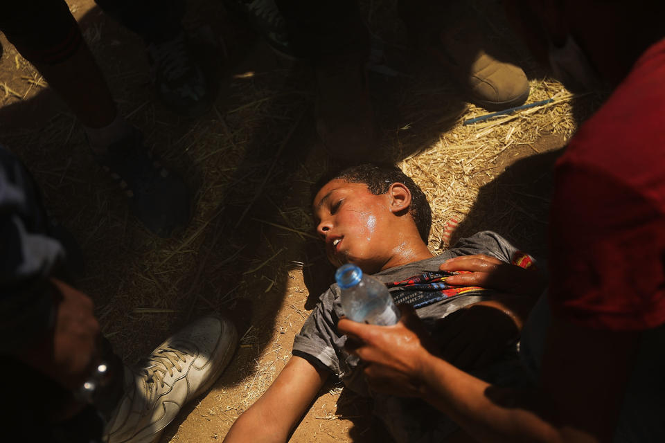 A child overcome by tear gas receives medical help.&nbsp;