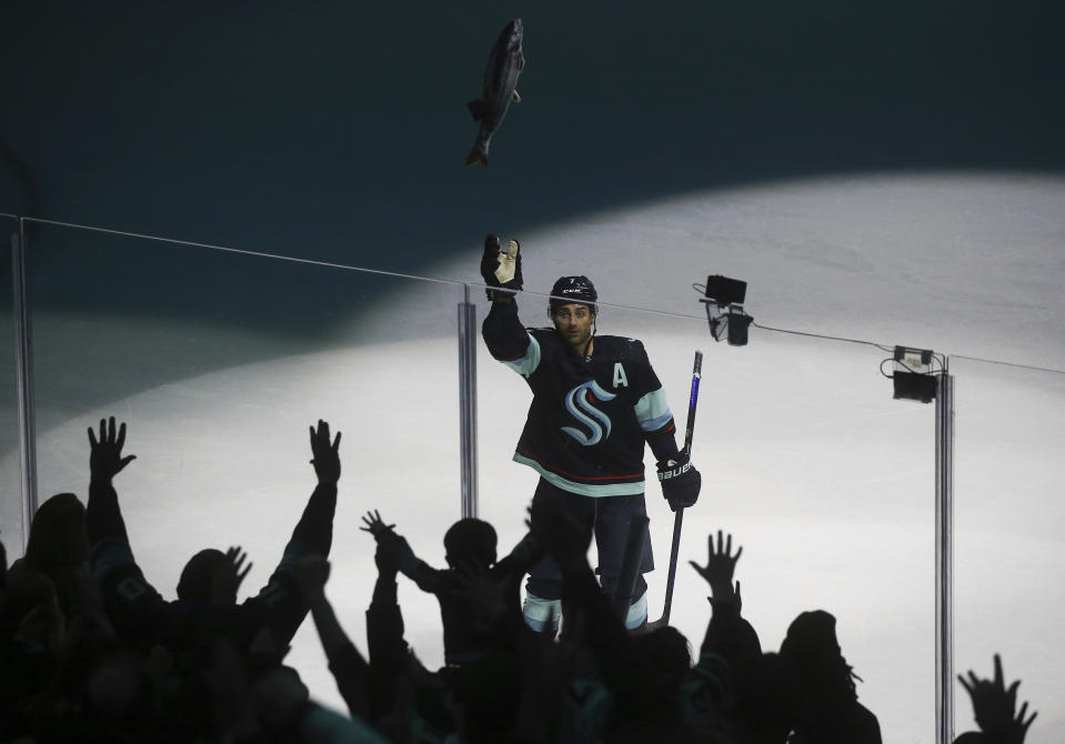 Seattle Kraken right wing Jordan Eberle (7) throws a stuffed salmon to fans as they celebrate the Kraken's 4-2 win against the Detroit Red Wings in an NHL hockey game Saturday, Feb. 18, 2023, in Seattle. (AP Photo/Lindsey Wasson)