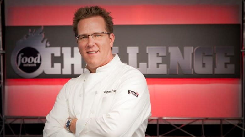 Keegan Gerhard stands in front of a Food Network Challenge logo 