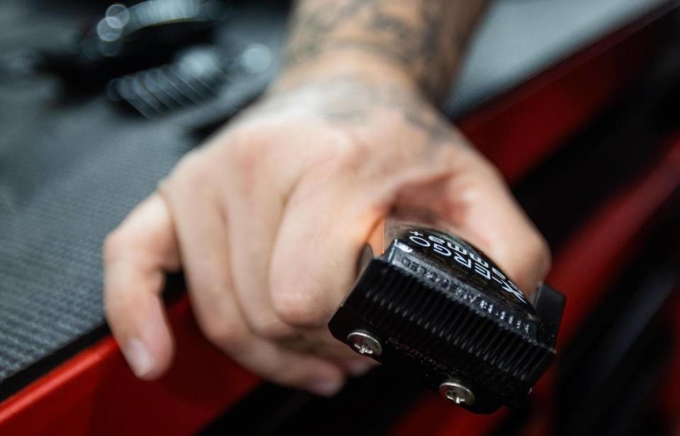 Owner Vinny Clark holds clippers as he cuts hair Friday, Aug. 12, 2022, at Texas Barber Cartel in Watauga.