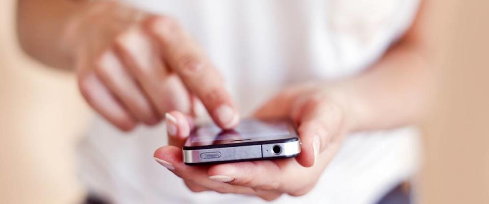 Young woman using apps on a mobile  touchscreen smartphone.