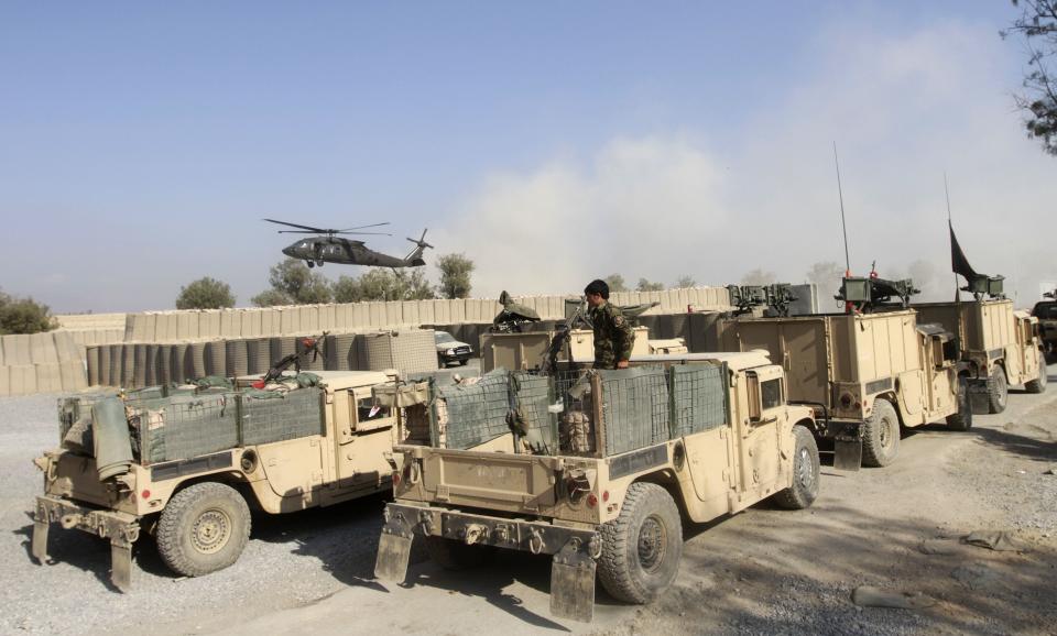 A NATO helicopter flies over the site of an attack by insurgents on a joint NATO-Afghan base in the Ghani Khel district of Nangarhar