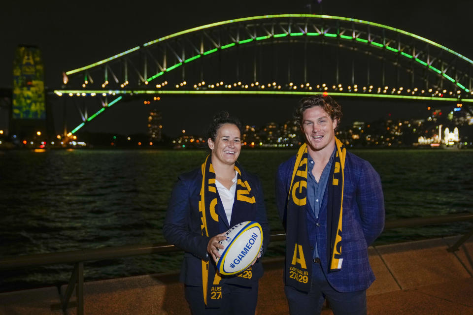 Wallabies captain Michael Hooper stands with Wallaroos captain Shannon Parry ahead of the final vote for the hosting of the Rugby World Cups in Sydney, Australia, Thursday, May 12, 2022. World Rugby will announce the host nations for the men's and women's World Cups for the period 2025-2033 with Australia heavily favored to host the men's 2027 and women's tournaments in 2029. (AP Photo/Mark Baker)