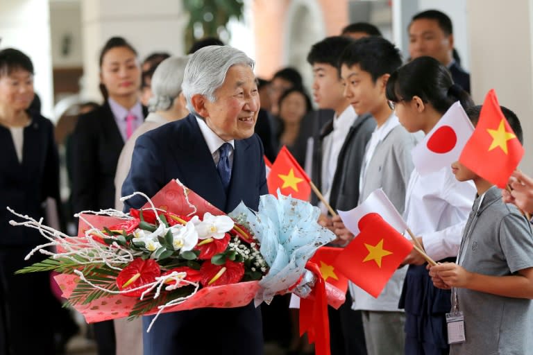 Emperor Akihito (centre) greets people after arriving at a hotel in Hanoi on February 28, 2017