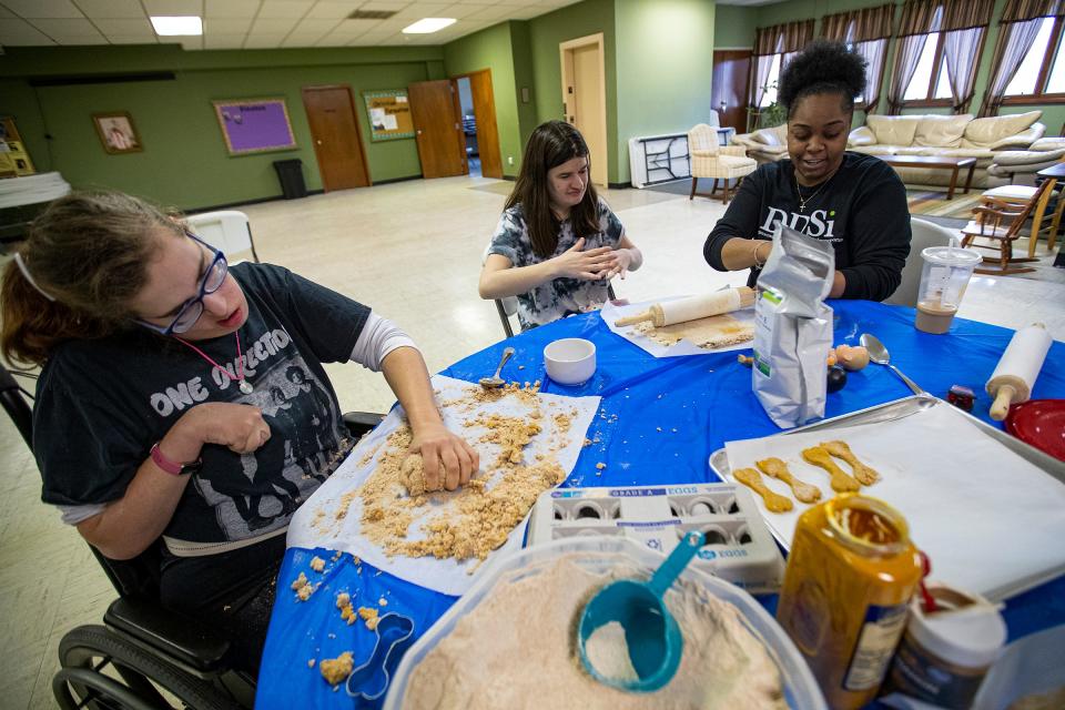 Carrie O'Brien (from left), Kaylee Davis and Tiana Ford knead together dough for dog treats on Thursday, April 14, 2022, at St. Alban's Episcopal Church in Indianapolis. Buttermilk Mountain, started by Jodi Maslanka, sells dog biscuits made by adults with disabilities at farmer’s markets and pet expos. The money goes back into the business and toward events and activities, like a picnic in the summertime for all bakers.