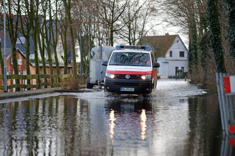 An emergency response vehicle drives through a flooded street in Lilienthal after the Wuemme River burst its banks. Residents can only reach their homes by boat. Markus Hibbeler/dpa