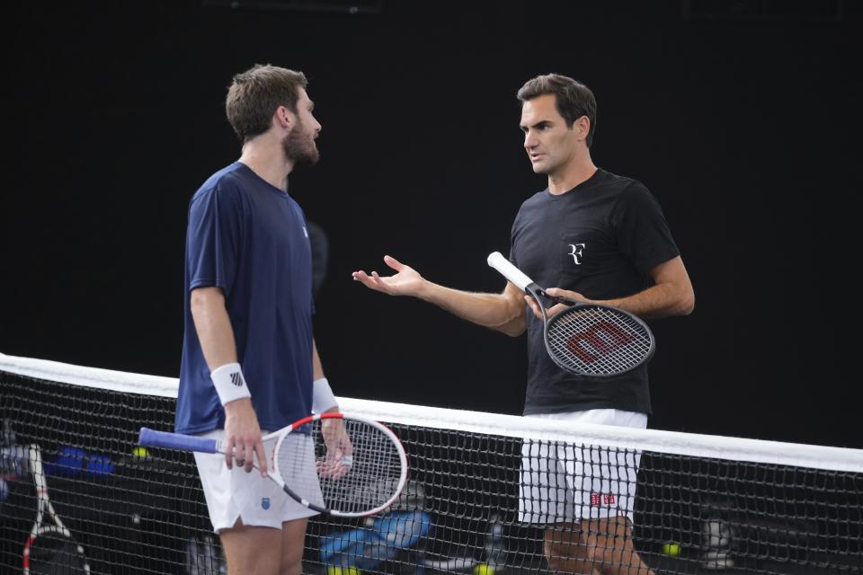 El tenista suizo Roger Federer (derecha) habla con el británico Cameron Norris durante los entrenamientos previos a la Copa Laver, en el O2 de Londres, el 21 de septiembre de 2022. (AP Foto/Kin Cheung)
