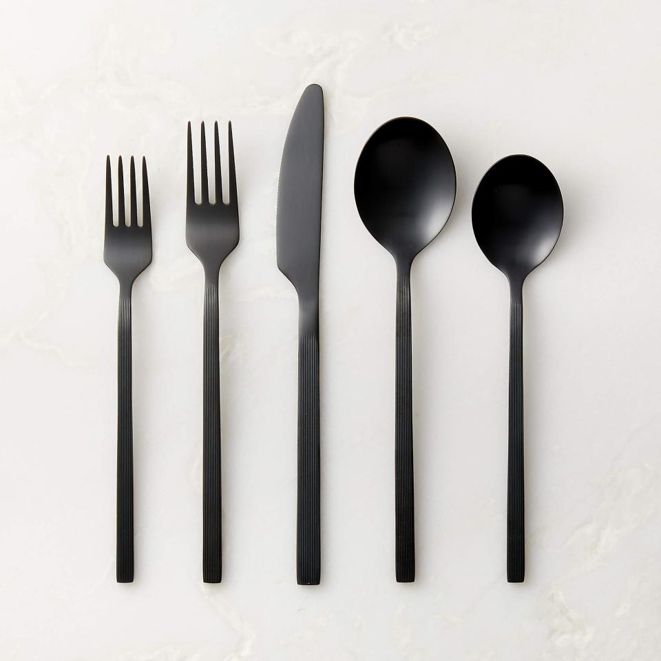 Five pieces of black silverware with pinstripe design