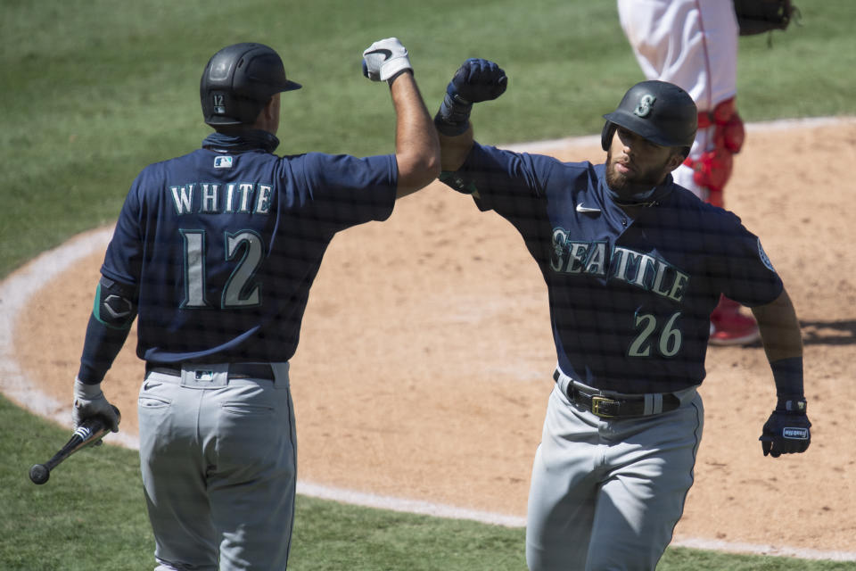 Seattle Mariners' Jose Marmolejos, right, and Evan White celebrate Marmolejos' solo home run during the sixth inning of a baseball game in Anaheim, Calif., Monday, Aug. 31, 2020. (AP Photo/Kyusung Gong)