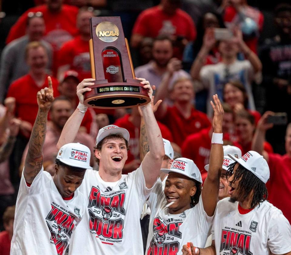 N.C. State’s Ben Middlebrooks (34) hoists the NCAA South Regional Championship trophy following the Wolfpack’s 76-64 victory over Duke, securing a spot in the Final Four on Sunday, March 31, 2024 at the American Airlines Center in Dallas, Texas.