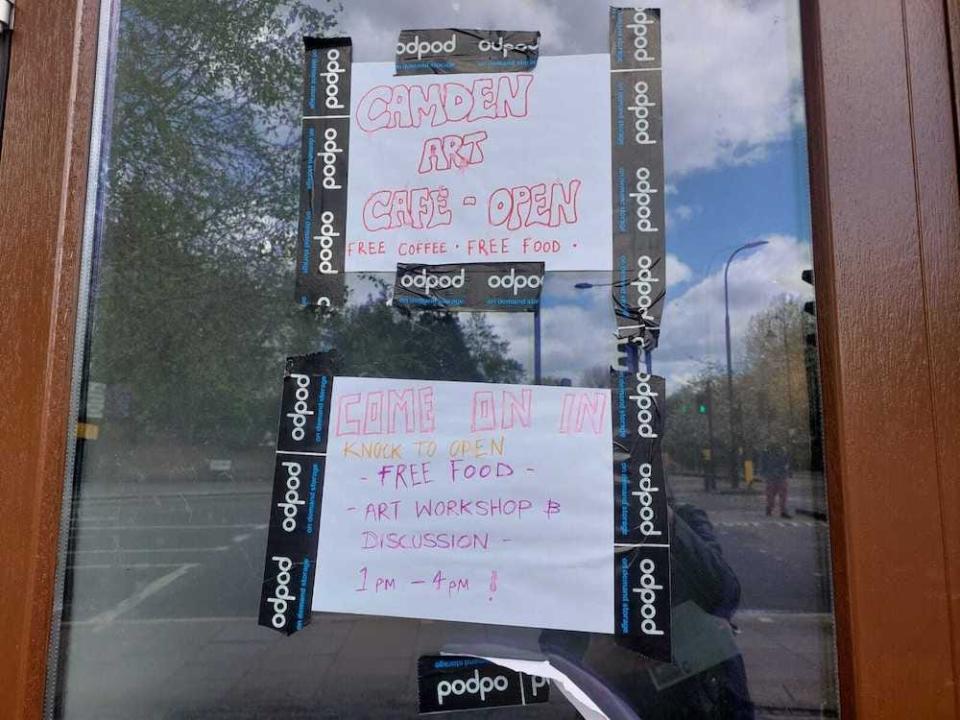 Two handwritten signs taped to the door of York & Albany, Gordon Ramsay's  hotel restaurant in Camden, London, on April 14, 2024, advertising "Camden Art Cafe - open" and saying "Come on in, knock to open, free food, art workshop and discussion, 1-4pm!'